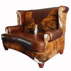 a brown leather chair with cow hide upholstered on it's back and arms