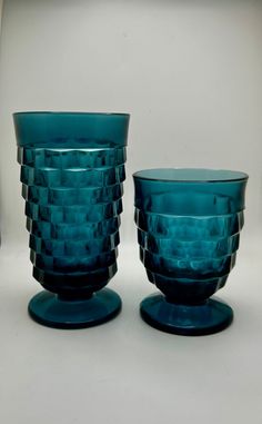 two blue glass cups sitting next to each other