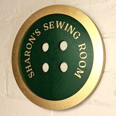 there is a green and gold sign on the wall that says aaron's sewing room