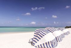 an umbrella on the beach with clear blue water in the background