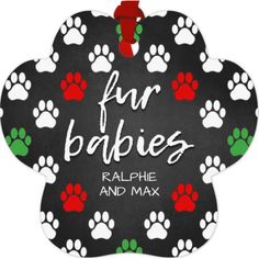 an ornament that says fur babies and paw prints on black with red, green, and white paws