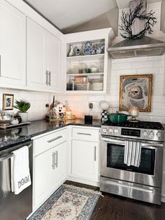 a kitchen with white cabinets and stainless steel appliances