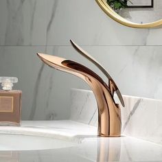 a bathroom sink with a gold faucet and marble counter top