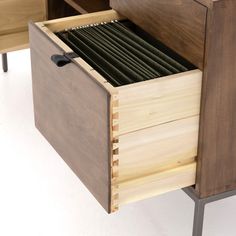 an open drawer with many files in it on a white surface and black metal legs