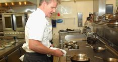 a man standing in a kitchen preparing food on top of a metal pan and frying pan