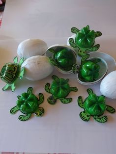 there are several green turtle figurines on the table next to onions and garlic