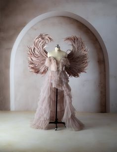 a mannequin dressed in pink with large wings