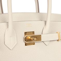 This Birkin is in Craie togo leather with gold hardware and has tonal stitching, front flap, two straps with center toggle closure, clochette with lock and two keys, and double rolled handles.The interior is lined with Craie chevre and has one zip pocket with an Hermes engraved zipper pull and an open pocket on the opposite side.Collection: WOrigin: FranceCondition: New and never worn (Plastic on hardware)Accompanied by: Hermes box, Hermes dustbag, clochette, lock, two keys, clochette dustbag, felt, carebook, ribbonMeasurements: 11.75" width x 9.5" height x 6" depth; 4.25" handle drop Luxury White Bags With Turn-lock Closure, Luxury White Bag With Turn-lock Closure, Luxury Everyday Bag In Togo Leather With Turn-lock Closure, Timeless Togo Leather Bag With Gold-tone Hardware, Classic Togo Leather Bag With Gold-tone Hardware, Luxury Everyday Calf Leather Bag With Lock, Timeless Togo Leather Bag With Lock, Timeless Bags With Metal Hardware And Togo Leather, Timeless Togo Leather Bag With Metal Hardware