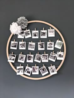 a circular wooden frame with pictures hanging on clothes pins and flowers in the middle, along with photos pinned to pegs