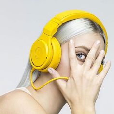 a woman with white hair wearing yellow headphones