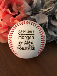 a baseball with the name morgan and alex for ever on it next to some flowers