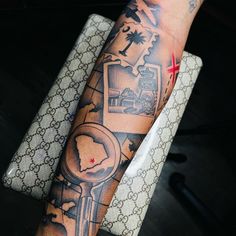 a person with a tattoo on their arm holding a clock and key to his chest