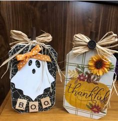 two tags decorated with sunflowers are sitting on a wooden table next to each other