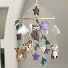 a mobile with several stuffed animals hanging from it's sides and stars on the ceiling