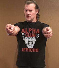 a man pointing at the camera while wearing a t - shirt that says, alpha club jergho