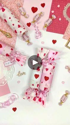 some pink and red paper with hearts on it's sides next to other items