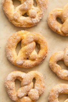 several sugared pretzels are arranged on a baking sheet