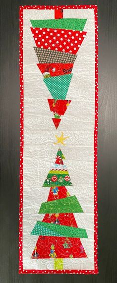 a quilted christmas tree hanging on the wall