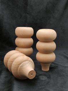 three wooden objects sitting on top of a black surface next to each other and one is made out of wood