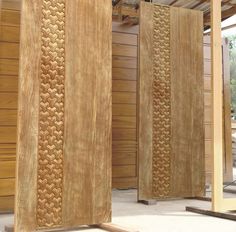 two wooden doors with intricate designs on them in a room that is being built into the wall