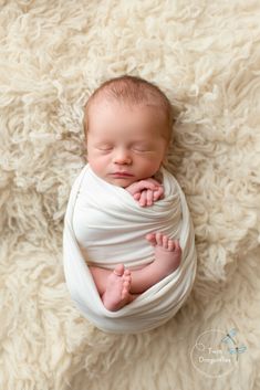 a newborn baby wrapped in a white blanket