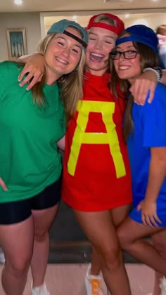 three girls in costumes posing for the camera with their arms around each other and smiling