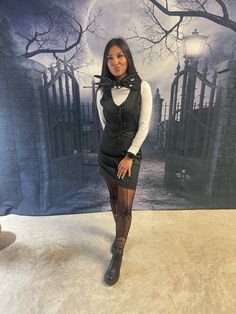 a woman standing in front of a wall with a creepy scene on it's side