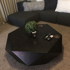 a black coffee table sitting on top of a carpeted floor next to a couch