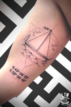 a man's arm with a tattoo on it that has an image of a sailboat