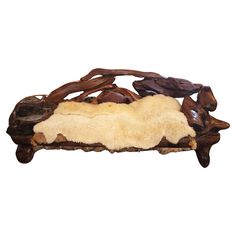 an animal skin is laying on top of some branches and wood pieces in the shape of a bench