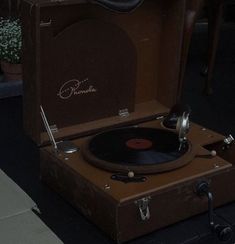 an old record player sitting on top of a suitcase