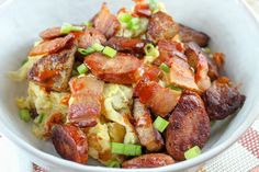 a white bowl filled with bacon, eggs and celery on top of a checkered table cloth