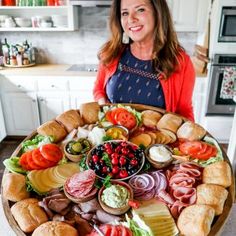 a woman standing in front of a large platter of food