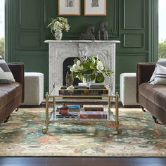 a living room with two couches and a coffee table in front of a fireplace