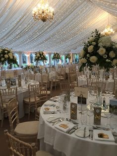 the tables are set up for an elegant wedding reception with white flowers and greenery