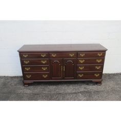 a large wooden dresser with two doors and drawers