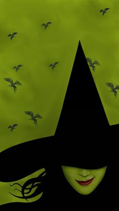 a woman wearing a black witches hat with birds flying around her and the background is green