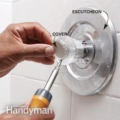 a person fixing a shower faucet on a white tile wall with instructions to fix it