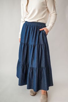 Perfect for a spring picnic or an everyday morning, the 'Celeste' skirt is so lovely and versatile! Constructed from lightweight cotton denim for a comfortable fit that moves with you, this skirt features hidden side pockets and an elastic waistband. Falling in ankle-length tiers, this comfortable skirt will compliment any simple top. Fit: true to size! Style: functioning pockets, elastic waist, tiered Color: dark wash Fabric content: 100% cotton Care instructions: wash gentle cycle, cold; lay f Spring Picnic, Comfortable Skirts, Be Intentional, Simple Top, Modest Clothing, Garment Labels, Tier Skirt, Curated Gifts, Tiered Skirt