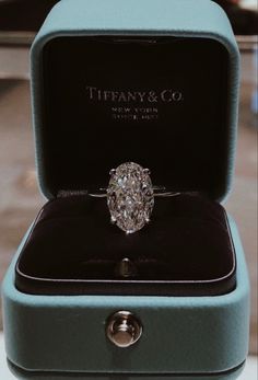 a diamond ring sitting in a blue box