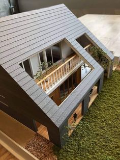 a model house is shown on top of a green carpeted area with stairs leading up to the second floor