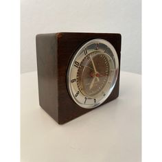 a small wooden clock sitting on top of a table