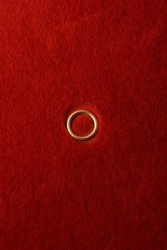 a metal ring on a red surface with a white spot in the middle that appears to be part of a piece of furniture