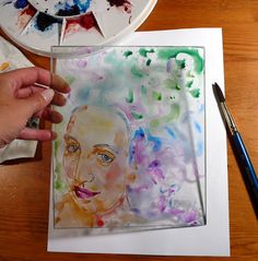 a person is painting with watercolors on paper