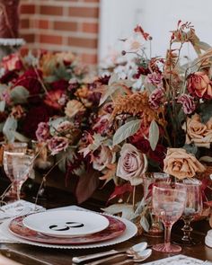 the table is set with flowers and plates