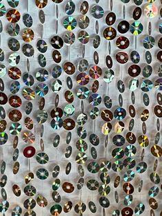 many different colored jewels are hanging on the wall