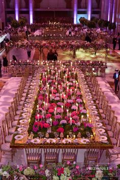 a long table is set with flowers and candles for a formal dinner or banquet event