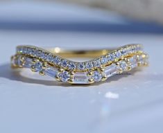 a gold ring with three rows of diamonds on it