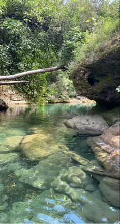 the water is crystal clear and green in this riverbed with rocks on both sides