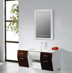 a white sink sitting under a mirror next to a wall mounted toilet paper dispenser